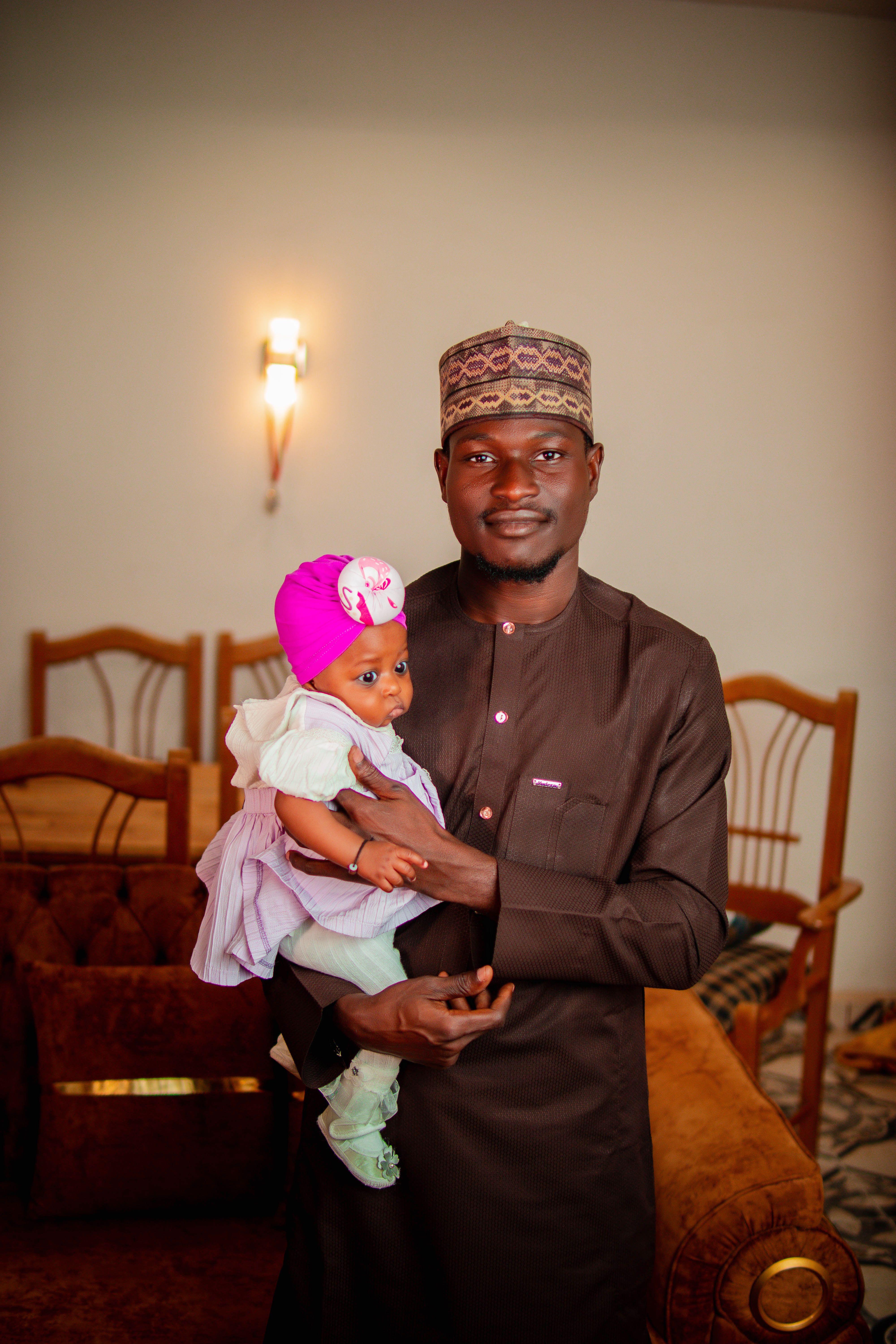 Father Holding Baby Girl in Traditional Attire · Free Stock Photo