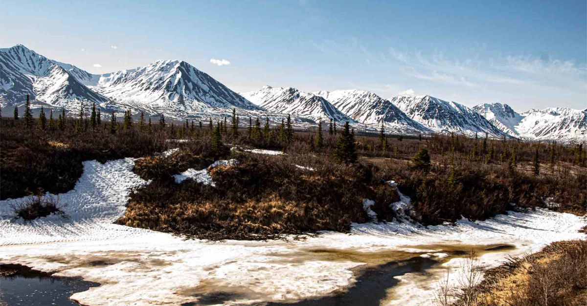 Snow-capped mountains and icy river with spring landscape in Alaska.