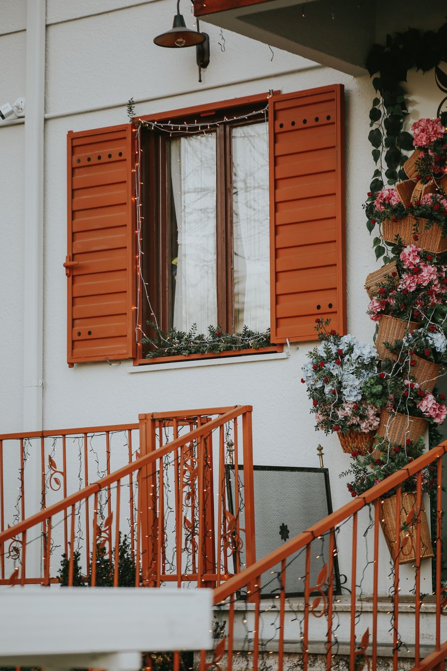 House front with orange shutters and flowers