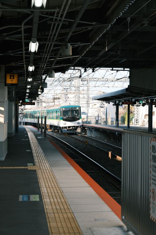Free A commuter train arrives at an urban platform in Kyoto, Japan, showcasing efficient rail transport. Stock Photo