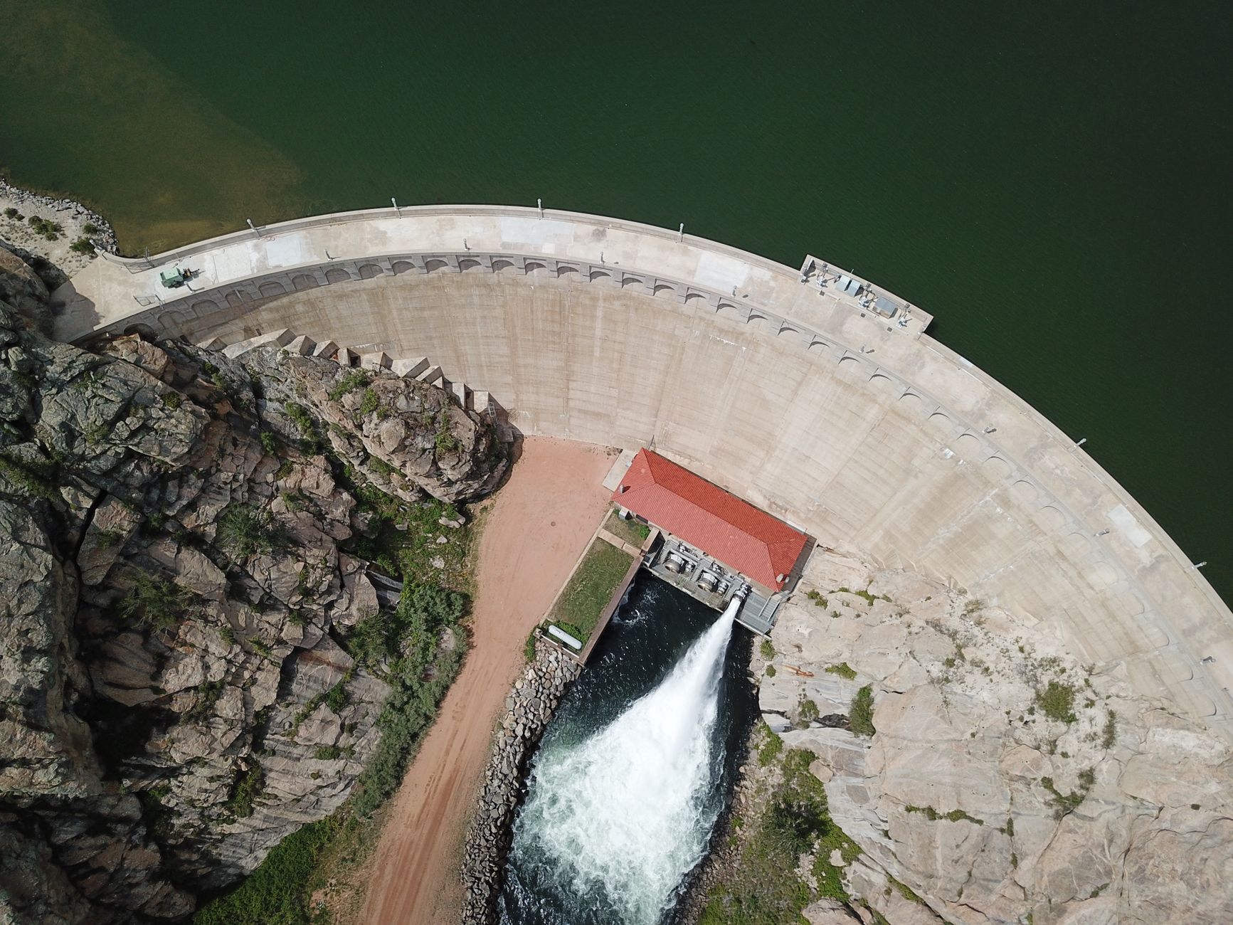 Stunning aerial shot of a dam with water release in Colorado, showcasing engineering and natural beauty.