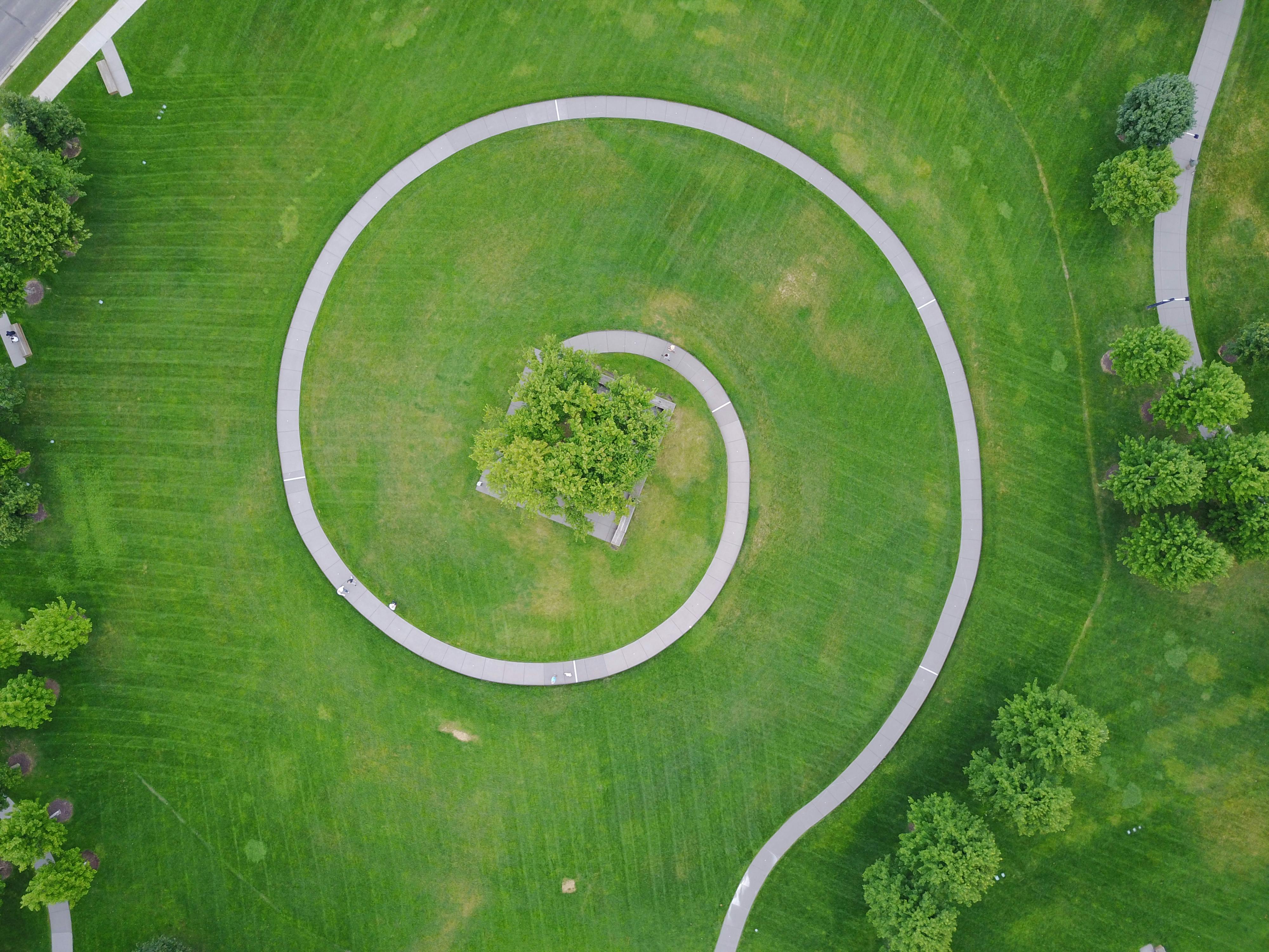 Drone shot of a spiral walkway amidst lush greenery in a Minneapolis park.