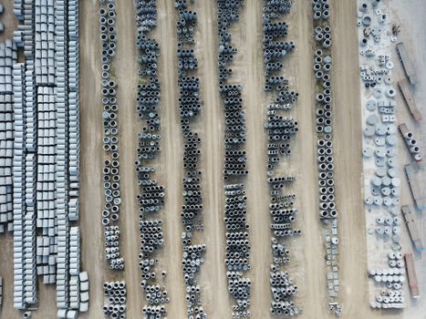 Drone shot of an organized outdoor concrete manufacturing facility with various pipes.