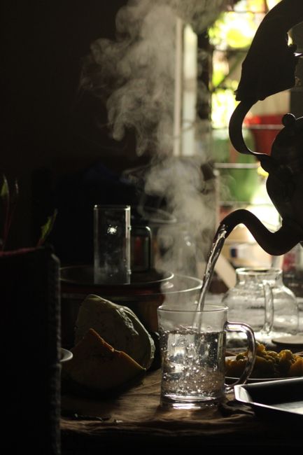 Fotomural Una tetera humeante vierte agua caliente en una taza de vidrio, creando una atmósfera acogedora y cálida en el interior.