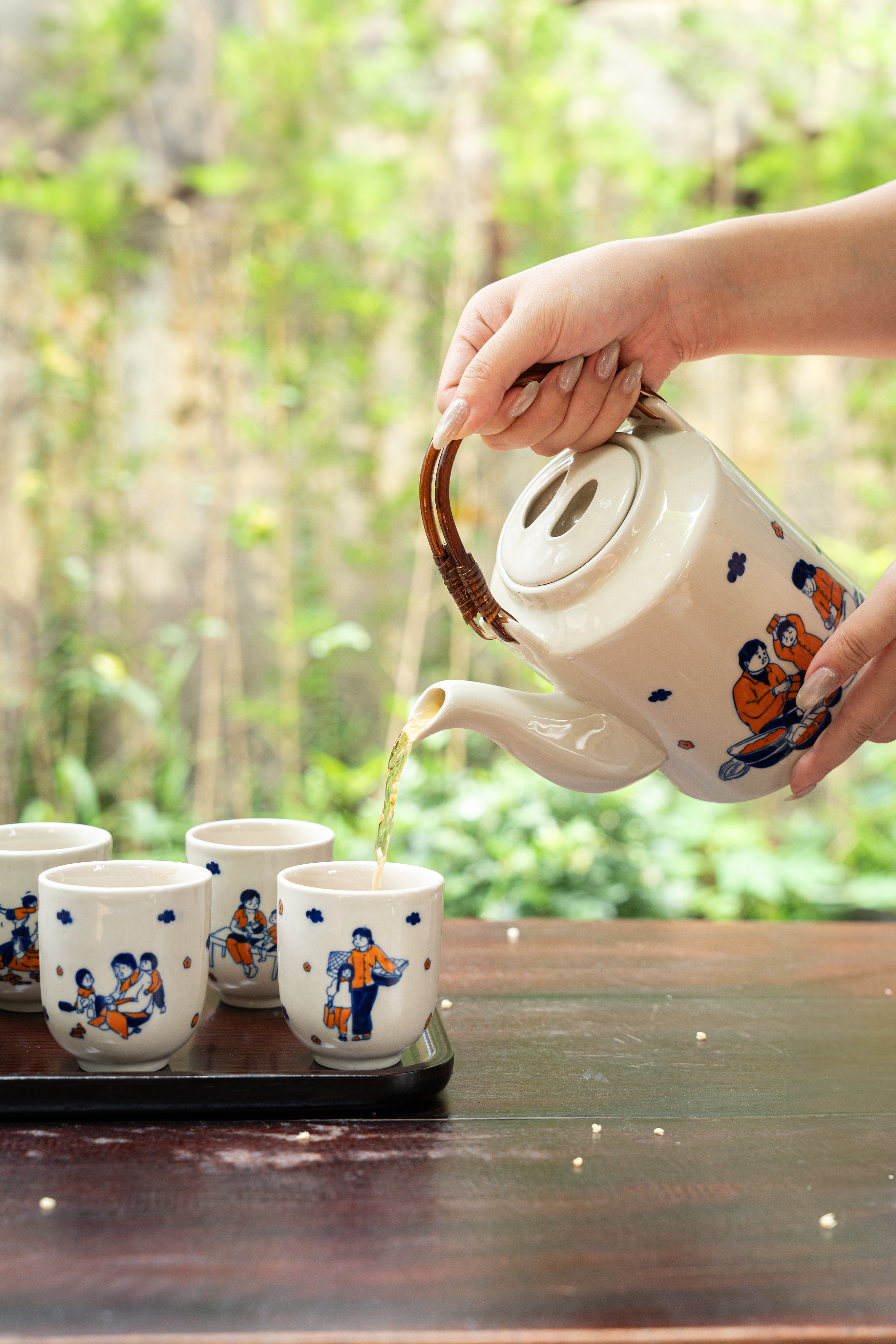 Pouring Tea in Traditional Ceramic Set Outdoors · Free Stock Photo