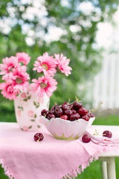 这幅迷人的夏季静物画以新鲜樱桃和户外花卉为装饰特色