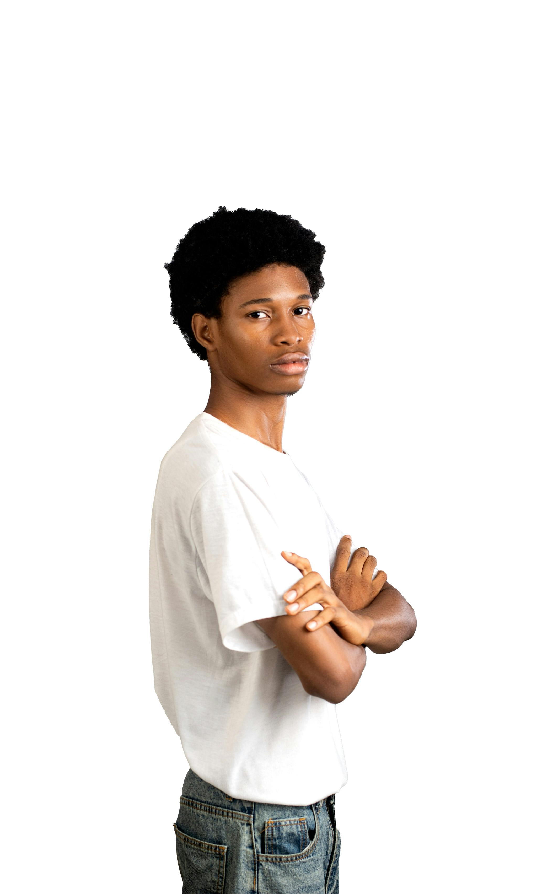 Gratuit Portrait d'un jeune adulte sûr de lui, vêtu d'un t-shirt blanc décontracté et les bras croisés. Photos