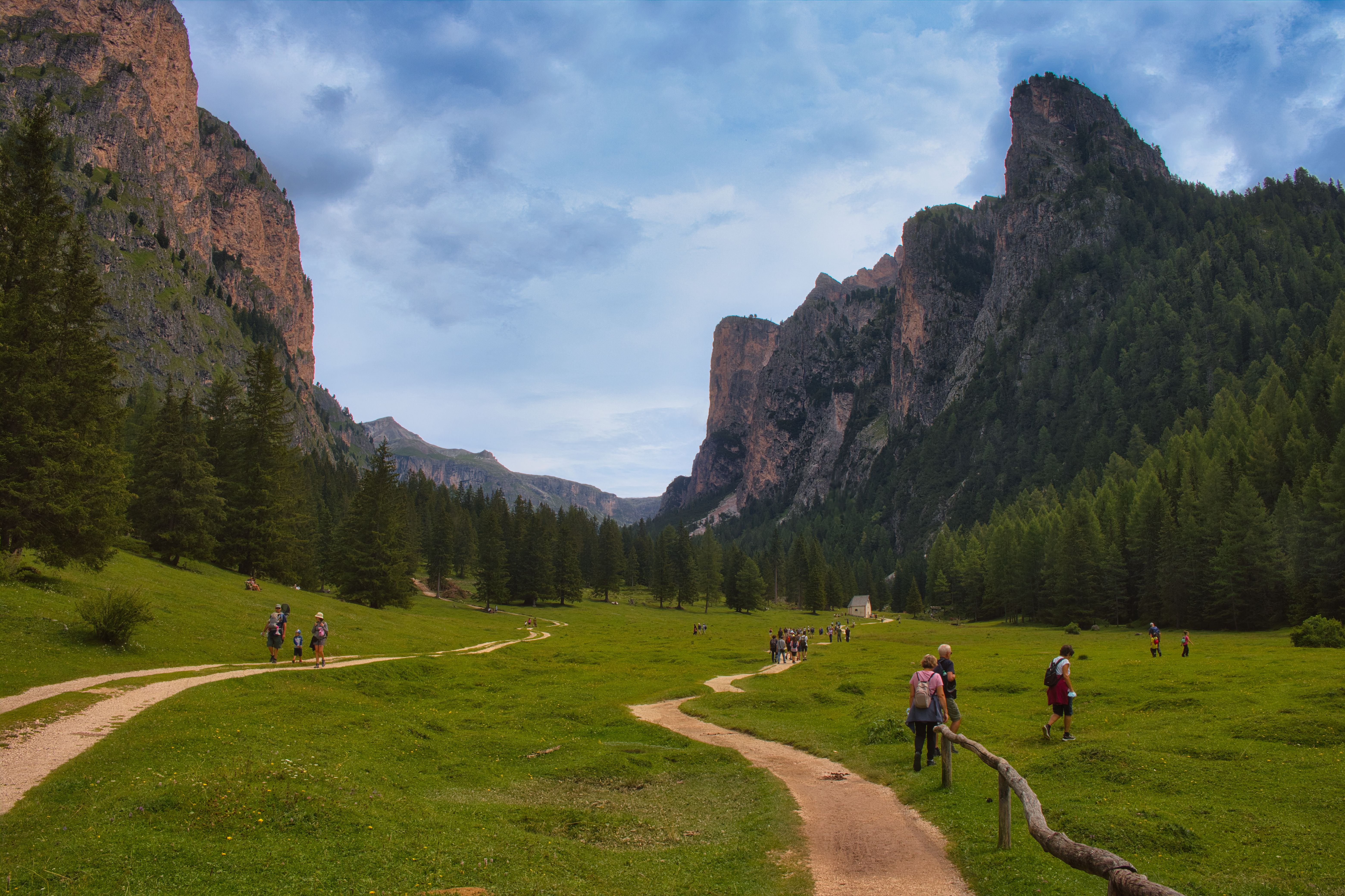 A picturesque hiking trail through the Dolomites in Selva di Val Gardena, Italy, surrounded by lush greenery and towering cliffs. A picturesque hiking trail through the Dolomites in Selva di Val Gardena, Italy, surrounded by lush greenery and towering cliffs.