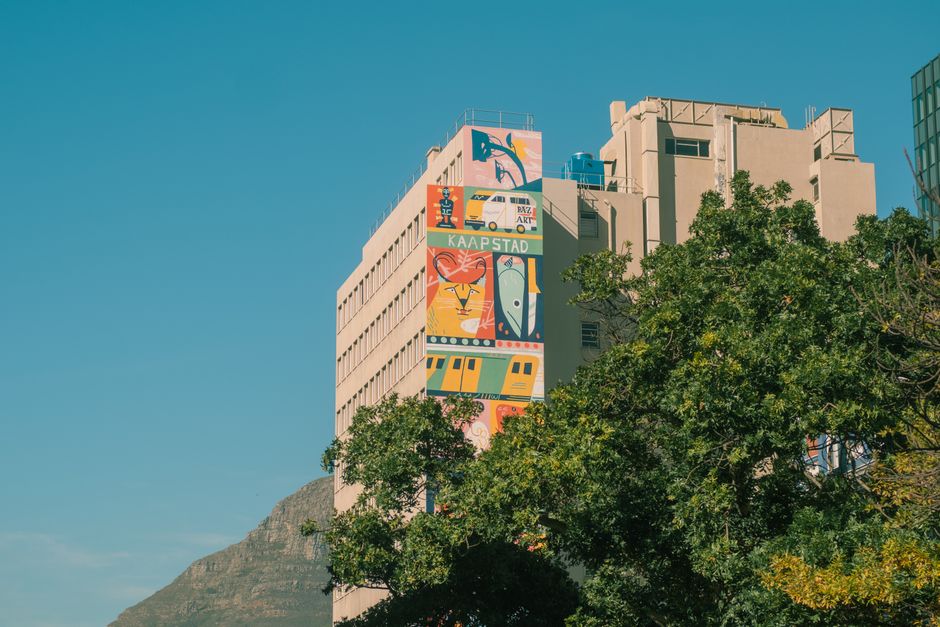 Vibrant mural on a building in Cape Town against a clear blue sky.