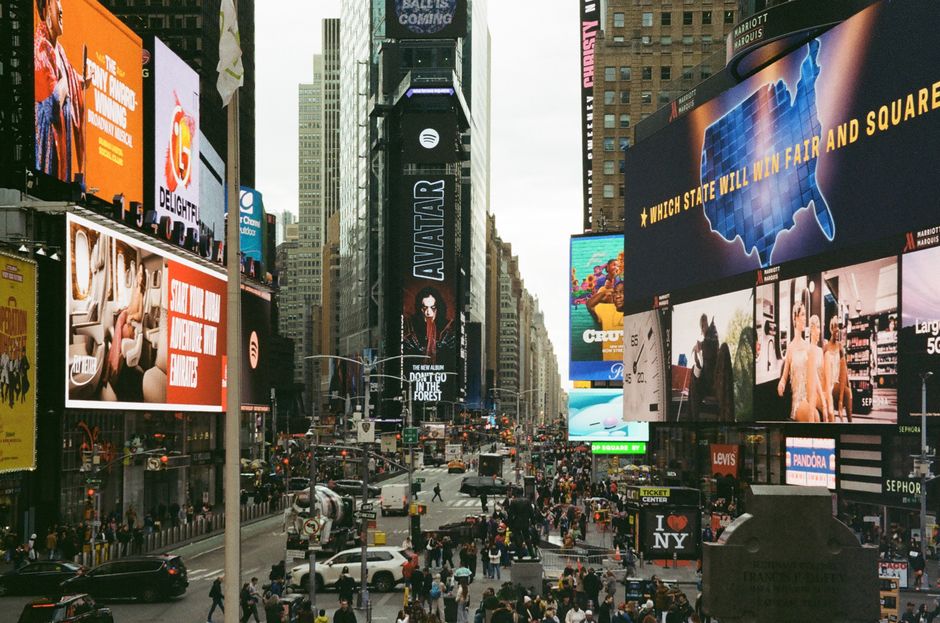 Times Square in New York City bustling with life, showcasing colorful billboards and busy crowds.