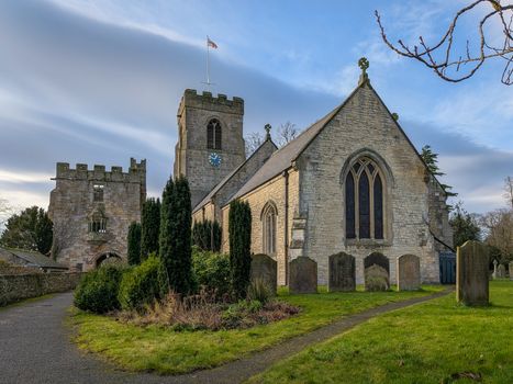A scenic view of St Nicholas Church and Marmion Tower in West Tanfield, England during winter.