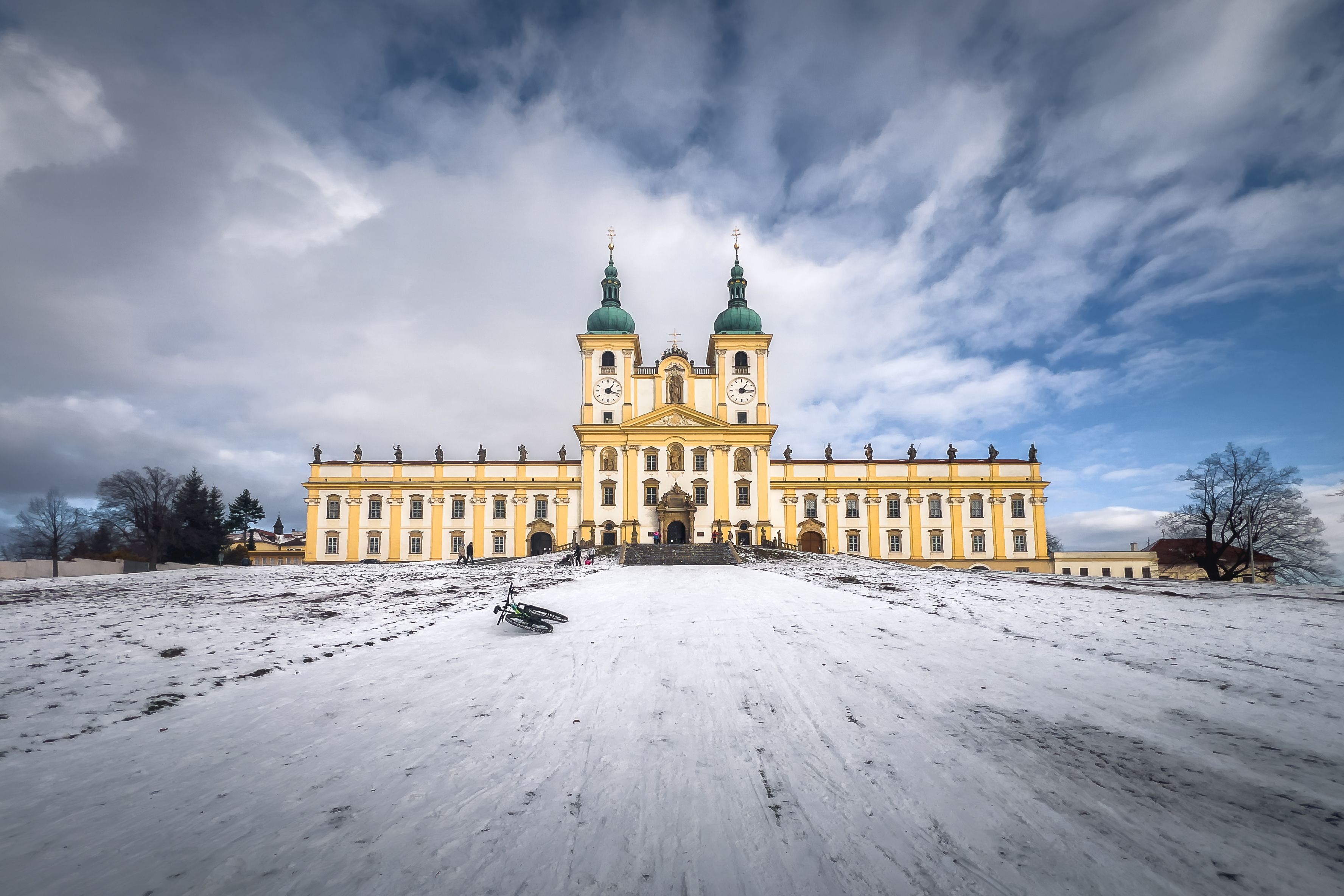 Majestic baroque church in a snowy landscape under dramatic skies, Olomouc, Czech Republic.