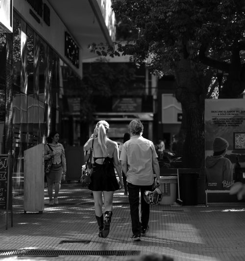 Free Monochrome image of a couple walking down a city street during the day. Stock Photo