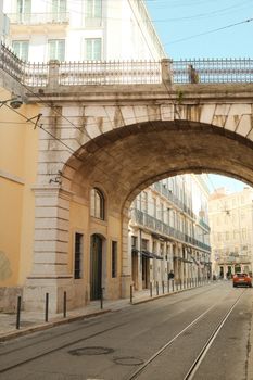 Charming Lisbon street with stone archway and classic architecture, capturing Portuguese charm.