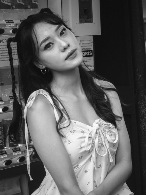 Free Elegant monochrome portrait of a young woman in a white dress in Jakarta, Indonesia. Stock Photo