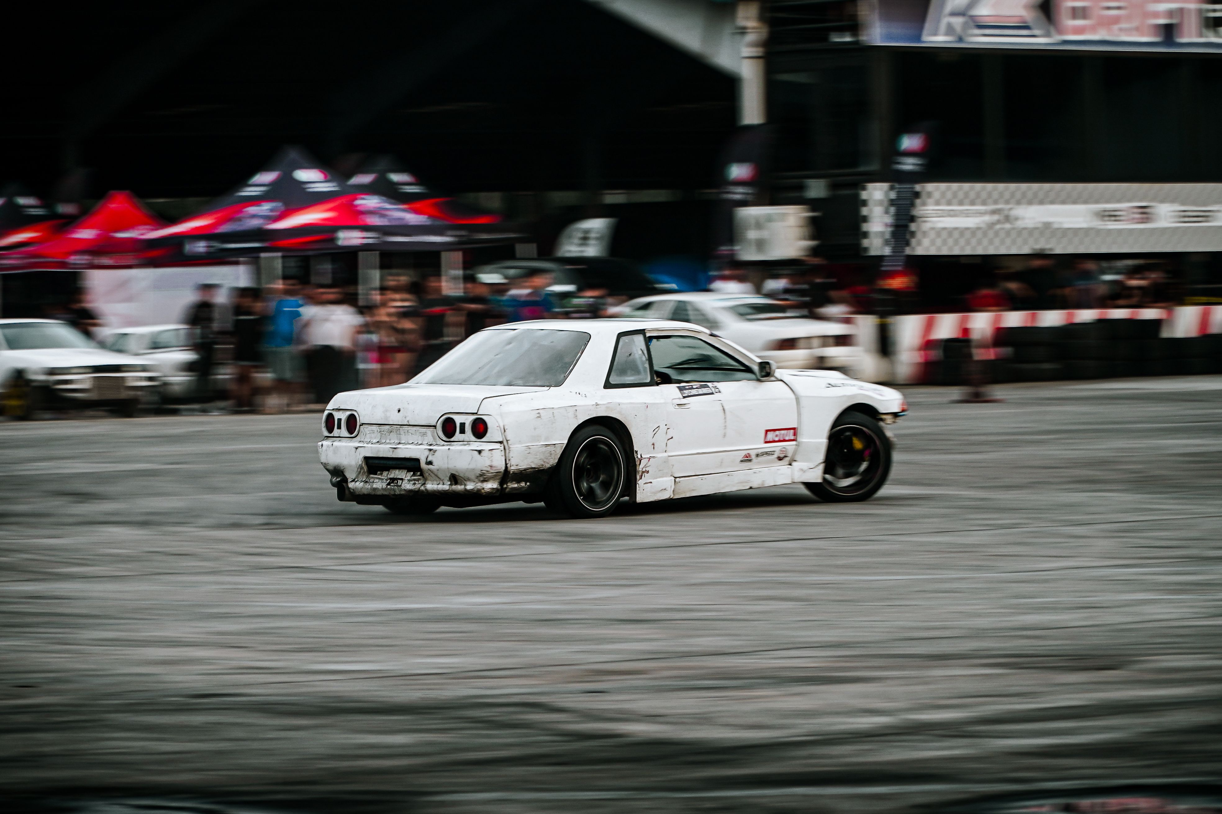 White sports car performing drift at racing event in San Simon, Philippines.