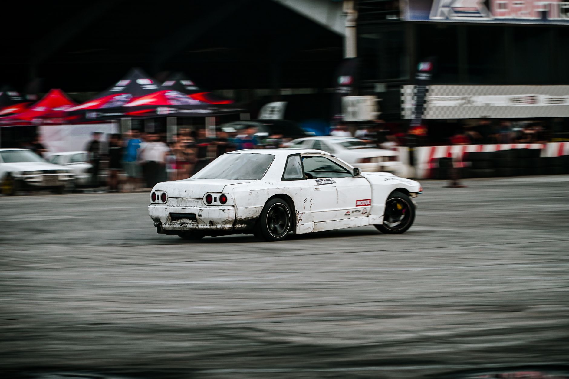 White sports car performing drift at racing event in San Simon, Philippines.