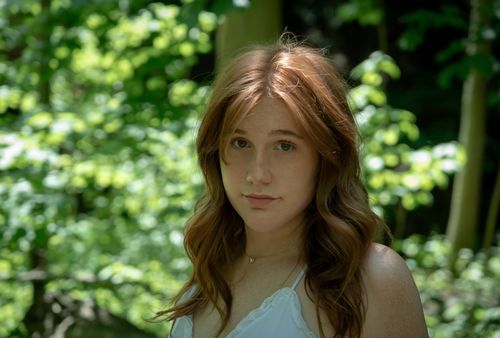 Free Beautiful red-haired woman in a natural forest setting, captured in soft spring light. Stock Photo