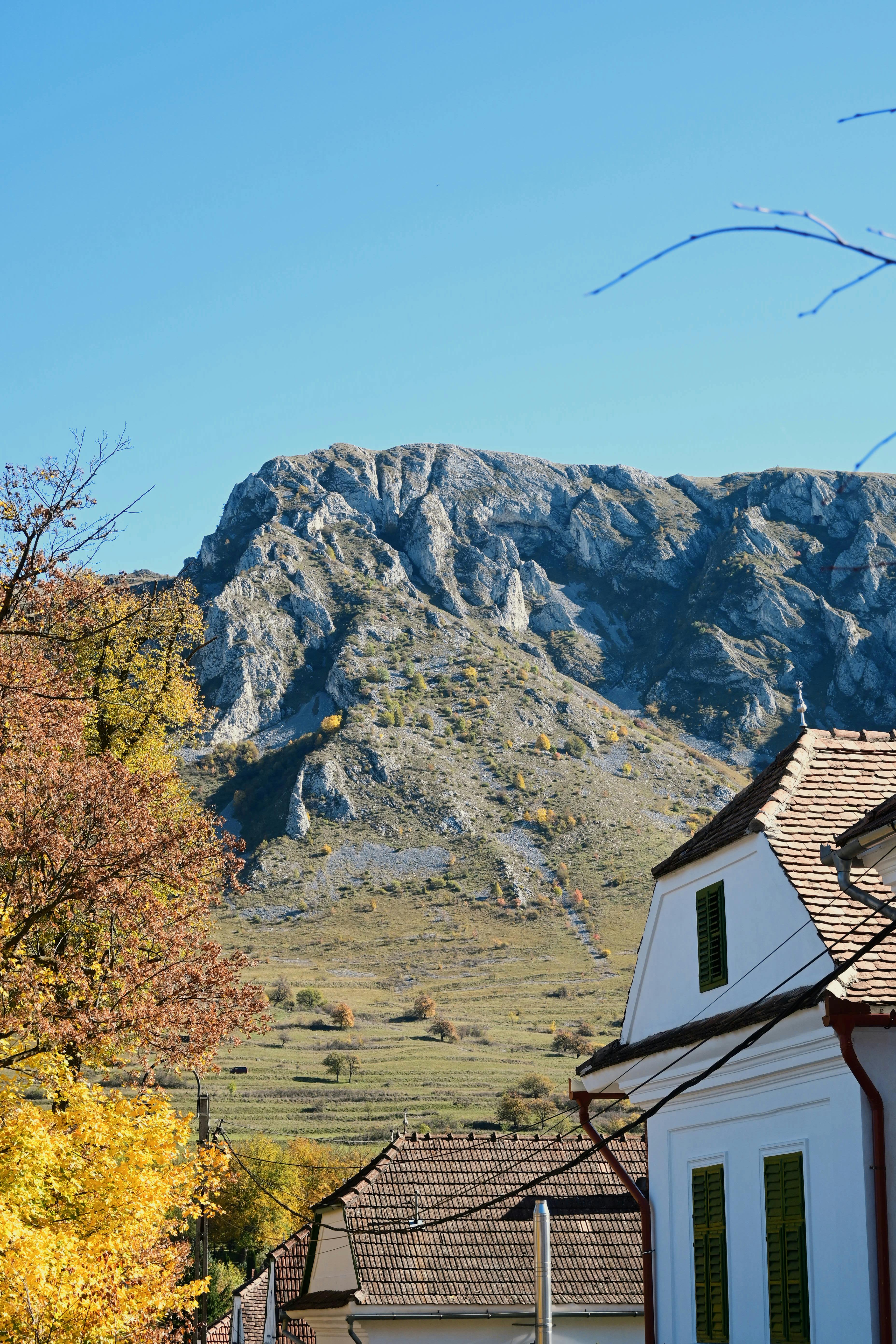 A picturesque village in Rimetea, Romania, surrounded by scenic mountains on a clear autumn day.