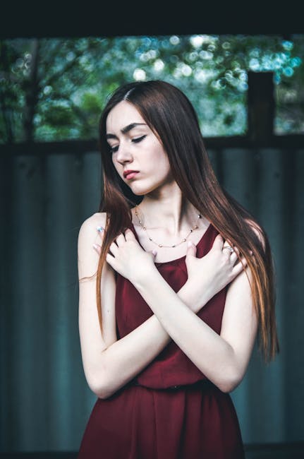 Woman Wearing Maroon Dress With Both Hands on Chest While 