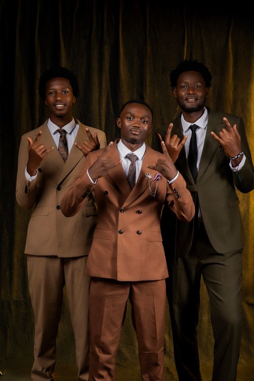 Free Three smiling men wearing elegant suits pose confidently against a dark background. Stock Photo
