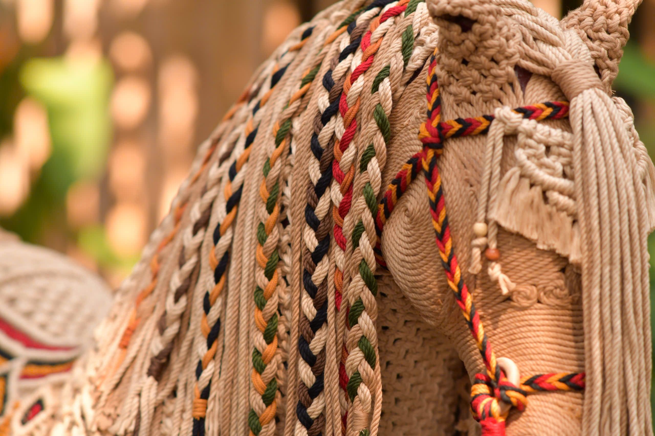 Close-up of detailed braided macramé art showcasing colorful patterns.