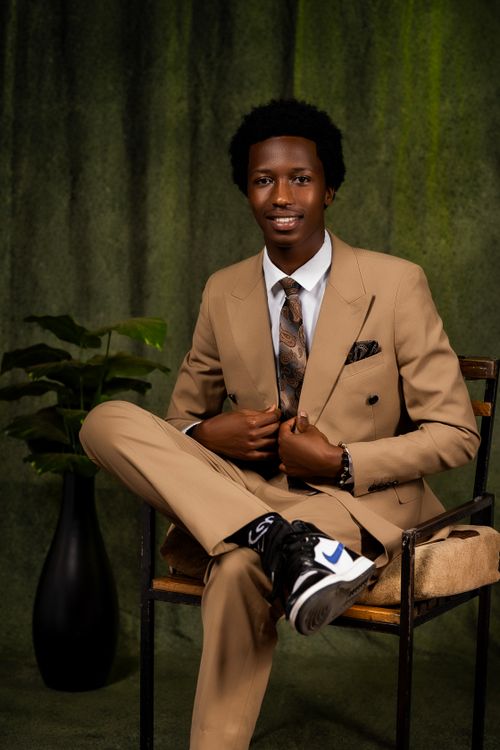 Free Elegant portrait of a smiling man in a tan suit with a green backdrop. Stock Photo