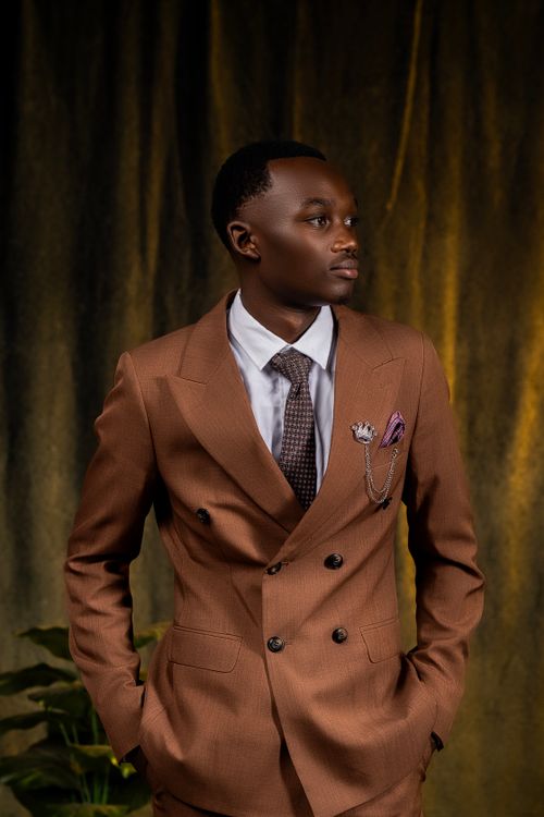 Free Portrait of a sophisticated man in a brown suit, exuding elegance and confidence indoors. Stock Photo