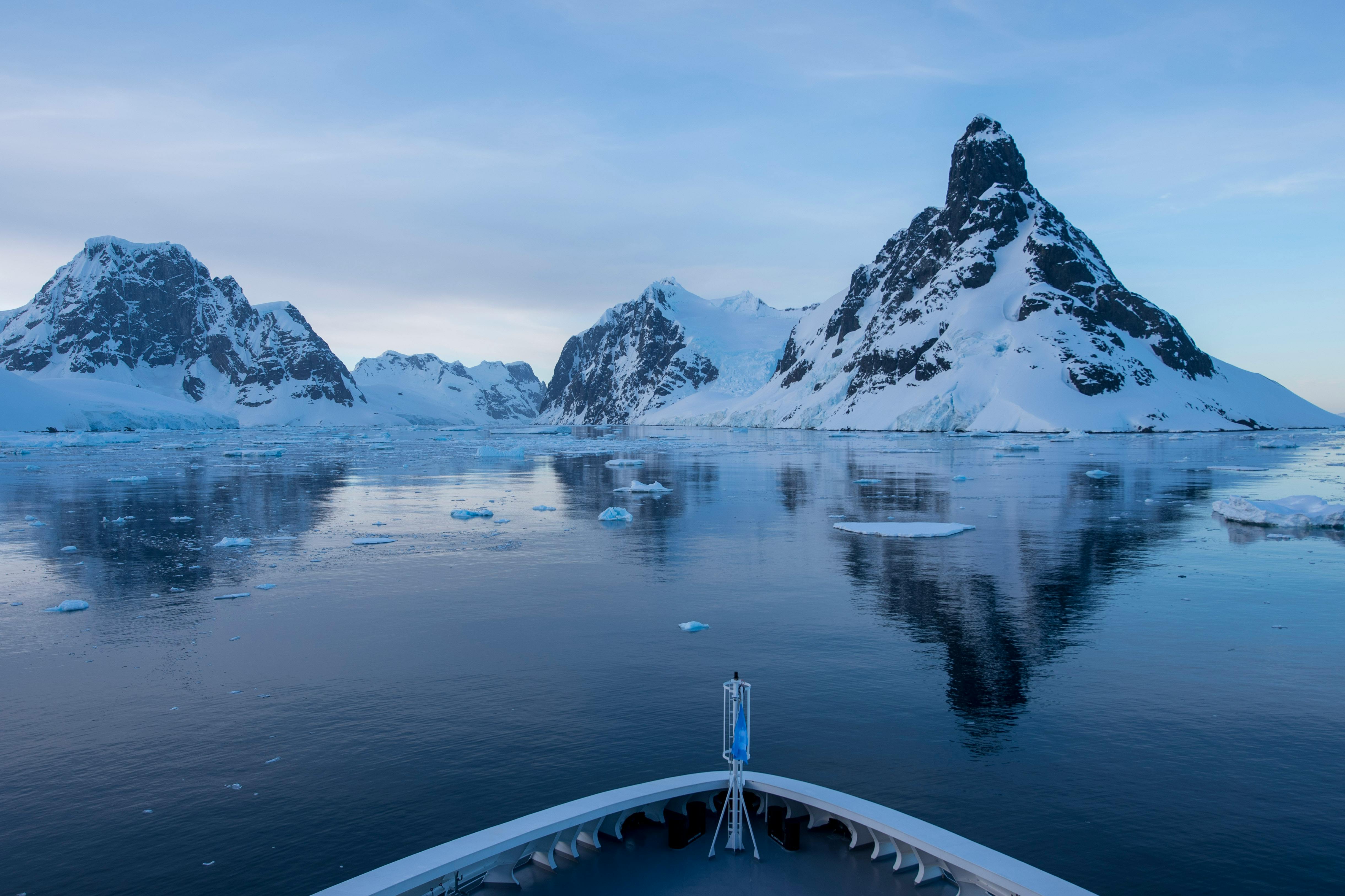 Stunning view of snow-covered mountains reflected in Antarctic waters.