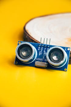 Close-up of an ultrasonic sensor module with a vibrant yellow background, ideal for tech and engineering themes.