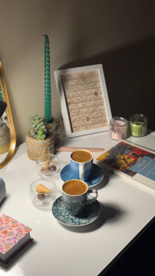 Free Warm cozy desk setup with coffee, books, and candles. Stock Photo