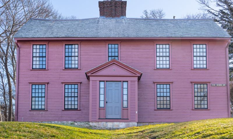 Historic colonial house on Main Street in Sandwich, Massachusetts, painted pink with a classic New England facade