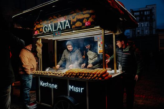 Street food vendor in Istanbul serving roasted chestnuts and corn at night. Captivating urban scene.