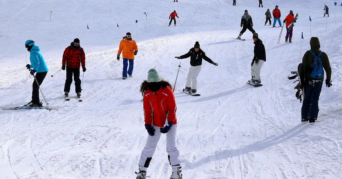 People skiing on a snowy slope in Bursa, Türkiye, enjoying winter sports under clear skies.