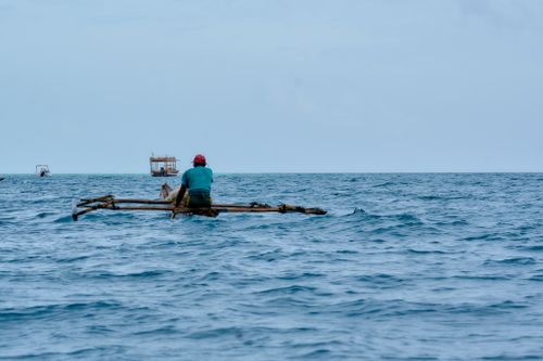 Free A fisherman navigates the Zanzibar ocean on a traditional dhow, capturing coastal life. Stock Photo