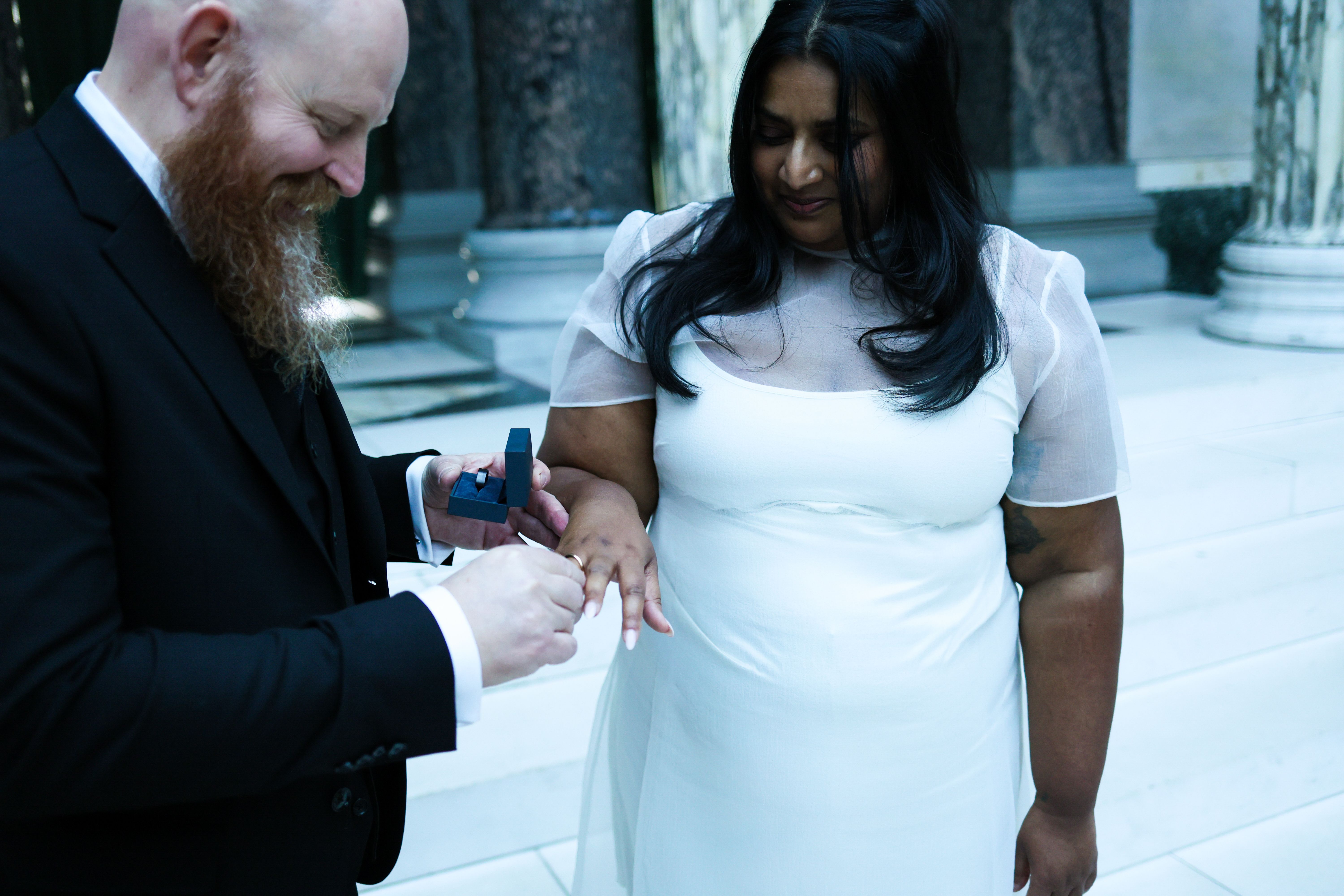 A touching moment as a man proposes to a woman inside a grand building.