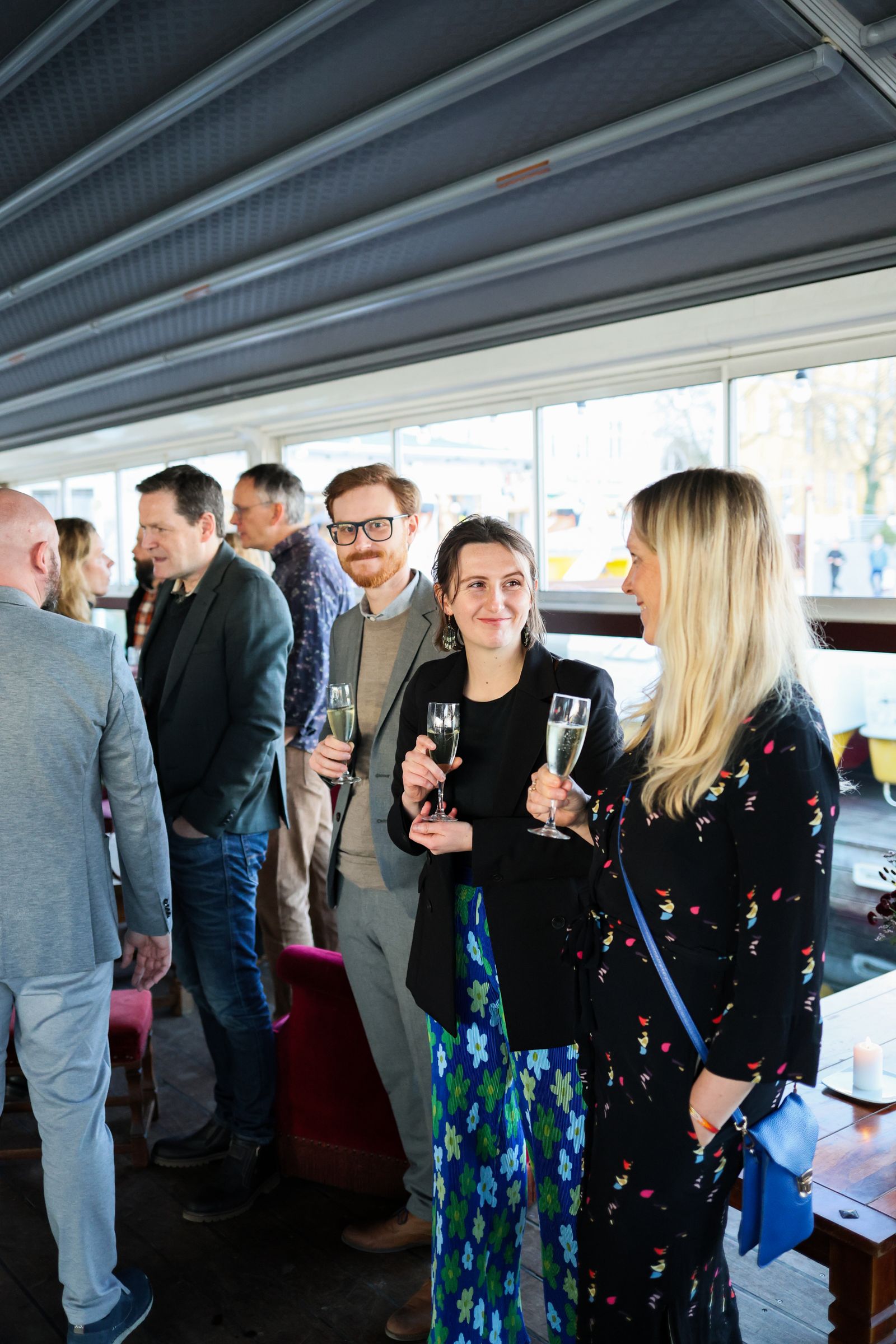 A busy indoor welcome reception with guests standing, talking and enjoying drinks