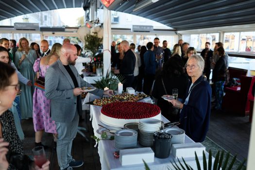 A stylish indoor gathering with diverse adults enjoying food and drinks.