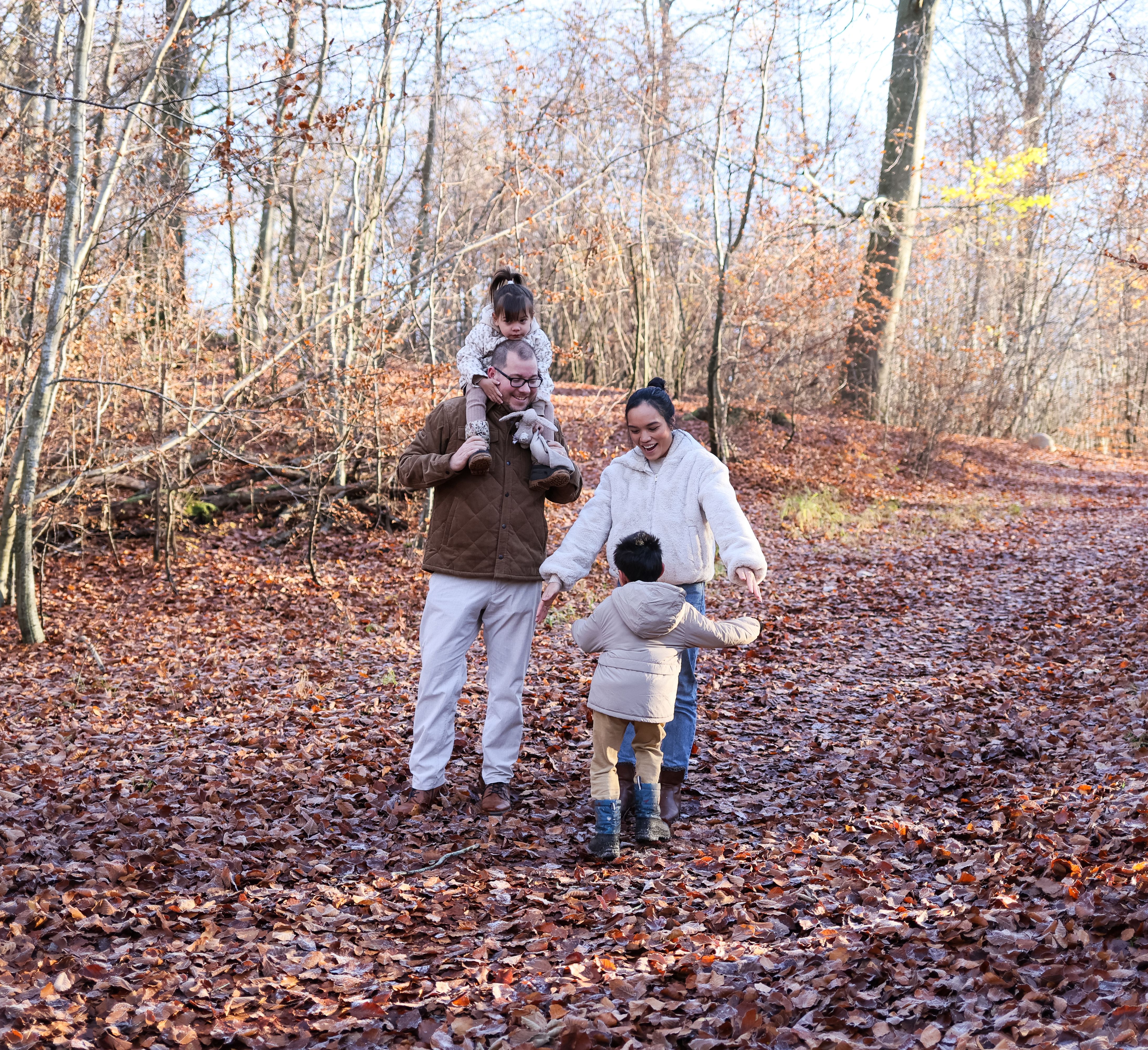Family enjoying fall walk through forest · Free Stock Photo