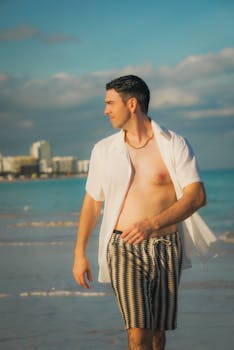 Man strolling on a sunny beach in casual summer wear.