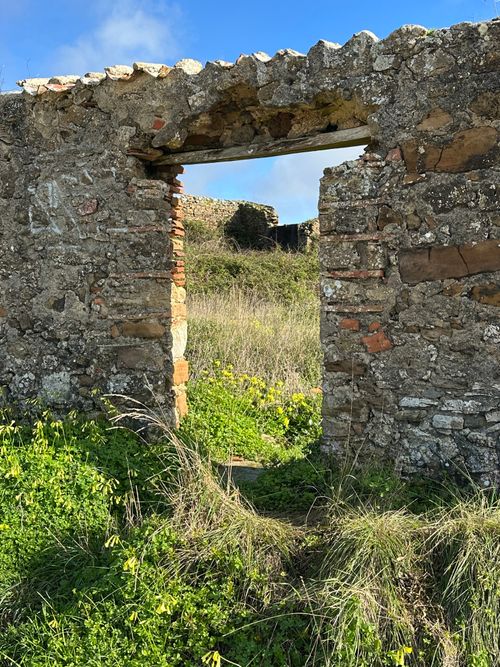 Free Weathered stone arch amidst green landscape under clear blue sky in Portugal. Stock Photo