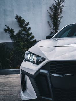 Front view of a sleek white sports car with LED headlights and bold design.