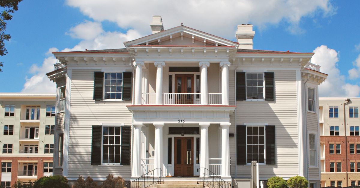 Elegant Southern colonial building with white pillars under a bright sky in North Carolina.