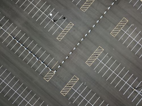Free Top-down view of a large, empty parking lot featuring clear lines and patterns. Stock Photo