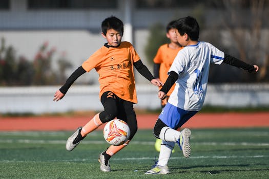 Two young boys in a dynamic soccer match outdoors on a sunny day.