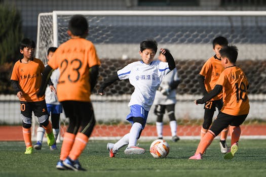 Exciting youth soccer match with boys playing under sunny skies. Captures team spirit and athletic skill.