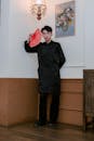 Man in Black Traditional Outfit Holding Red Fan