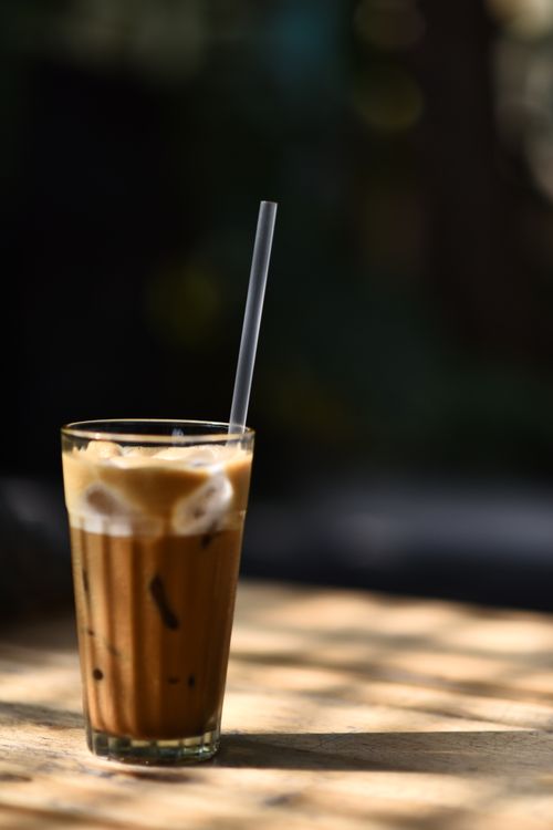 Free Glass of iced coffee with straw, perfect for a sunny afternoon. Stock Photo