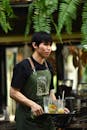 Waiter in Green Apron Serving Beverages Outdoors