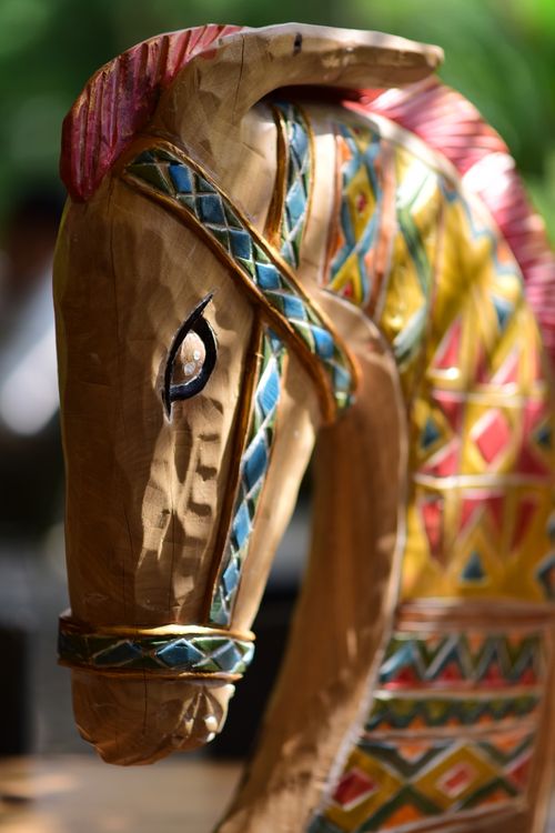 Free Close-up of a vibrant, patterned wooden horse sculpture in sunlight. Stock Photo